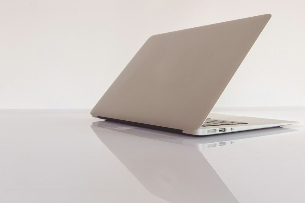 Silver laptop on a clean reflective desk